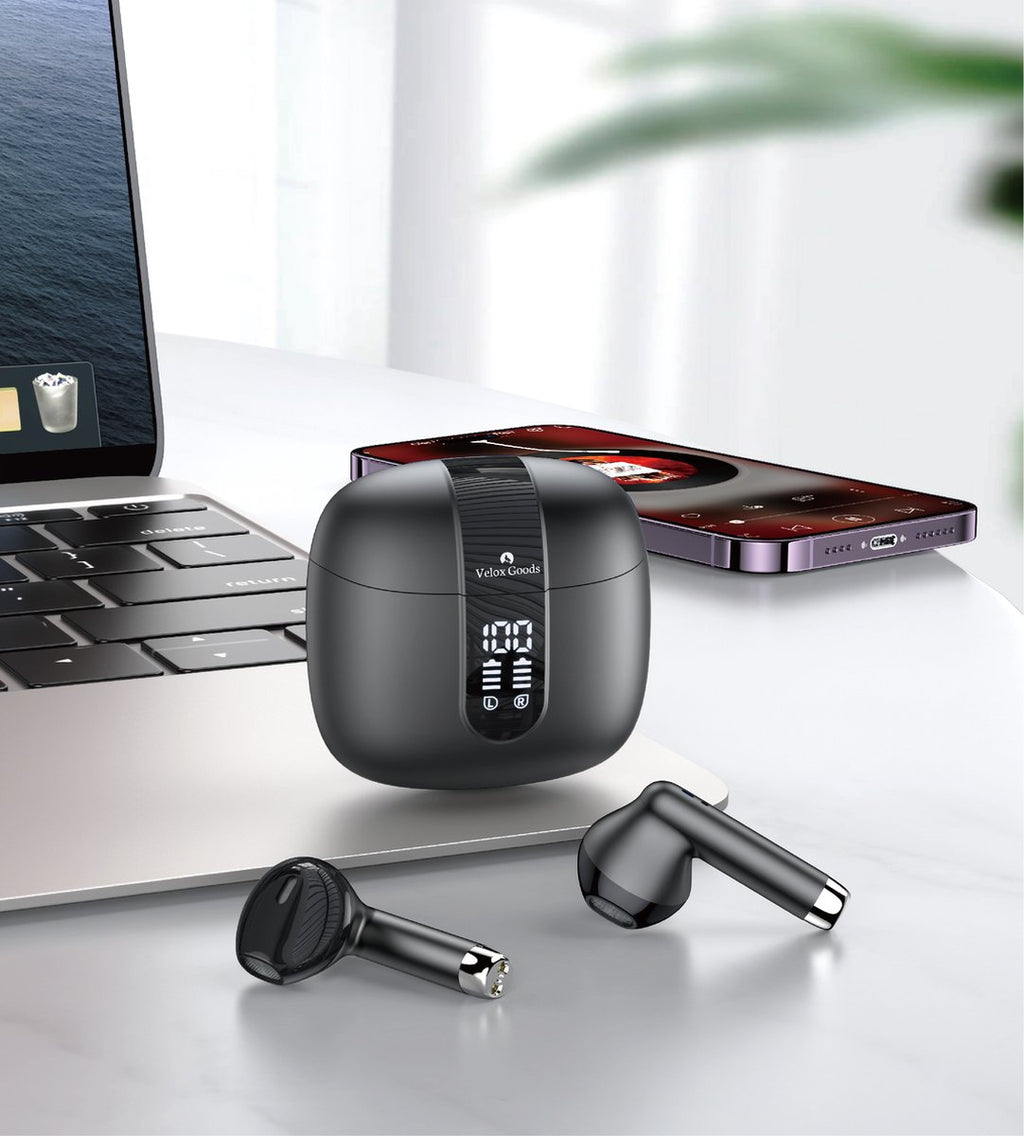 Oordopjes en oplaadcase op een bureau naast een laptop